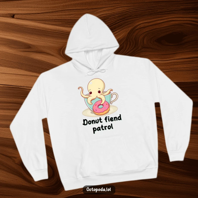 Funny Hoodie featuring a curious octopus peeking from a teacup, eyeing a donut with a single tentacle extended.